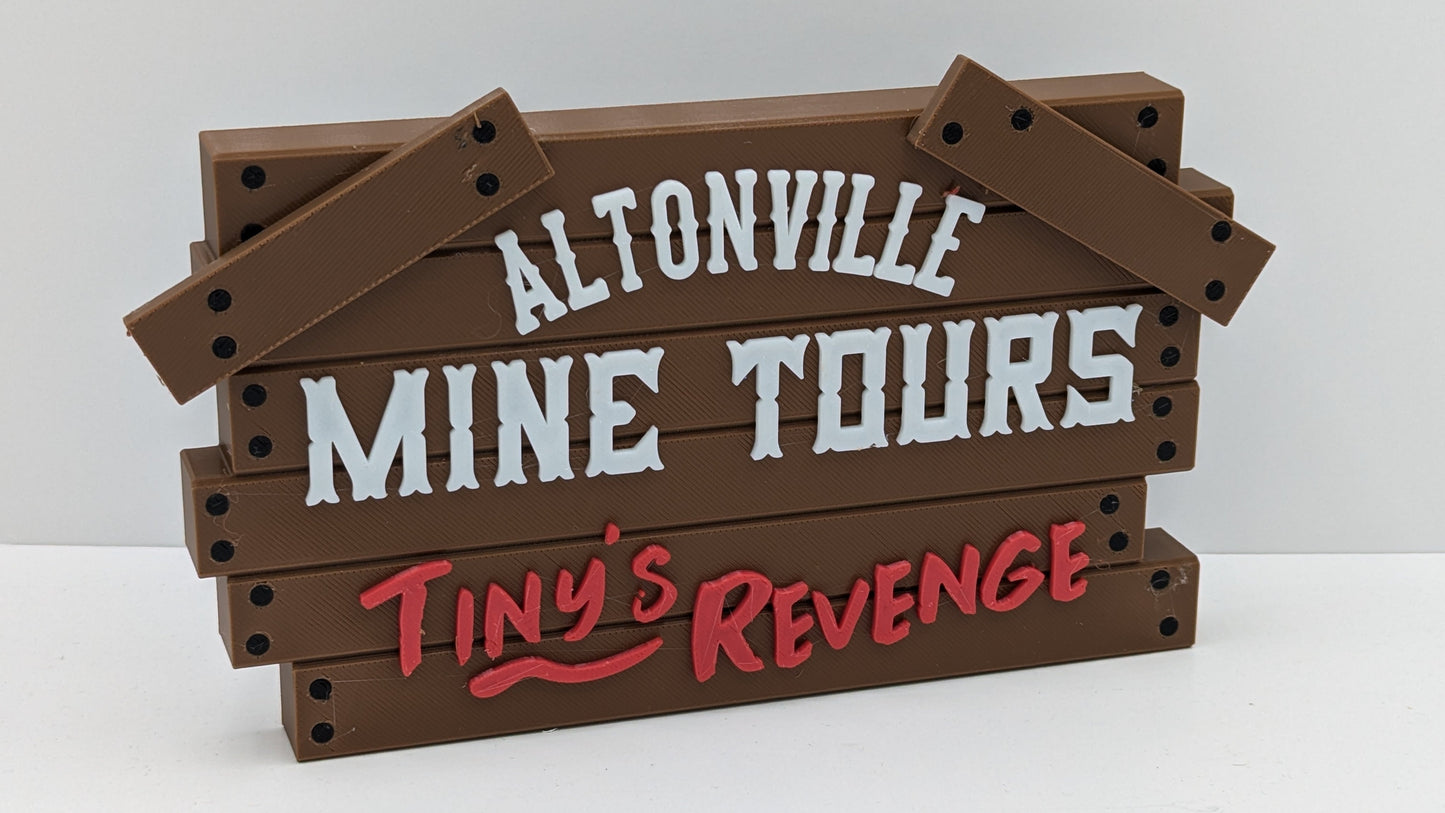 Wooden sign with 'Altonville Mine Tours' and 'Tiny's Revenge' text on a white background