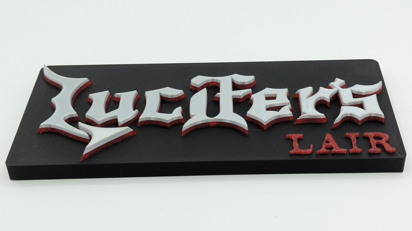 Decorative sign with 'Lucifer's Lair' text on a black background