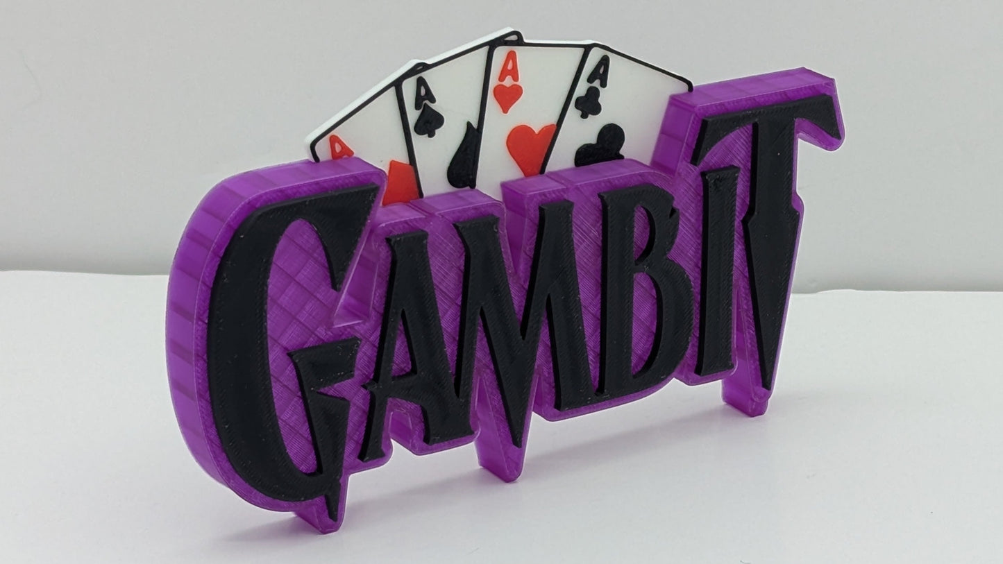 Purple and black 'Gambit' sign with playing cards on a white background