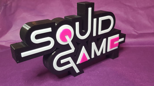 Sculpted 'Squid Game' logo on a purple background