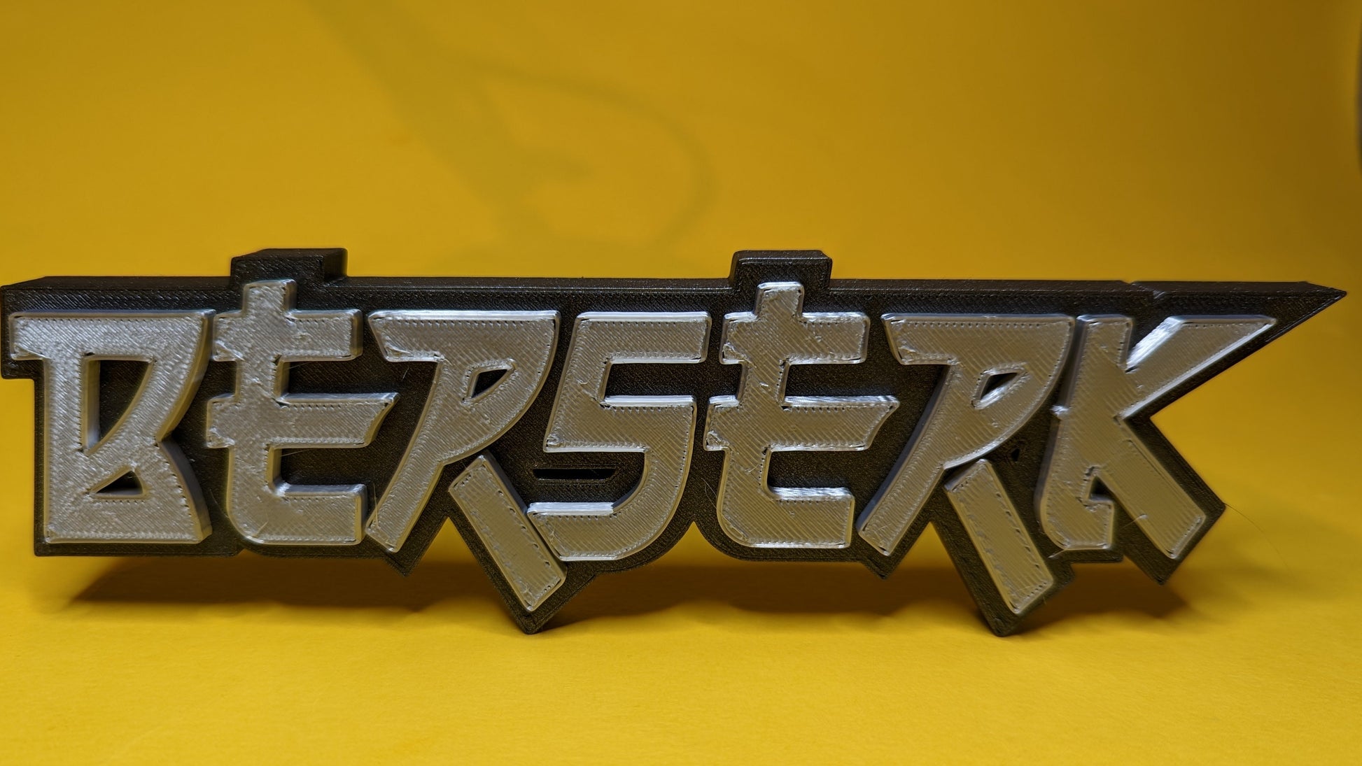 Metallic 'BERSERK' logo on a yellow background