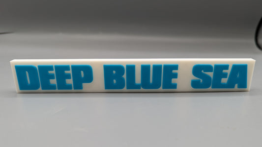 Rectangular rubber stamp with 'DEEP BLUE SEA' text on a gray background