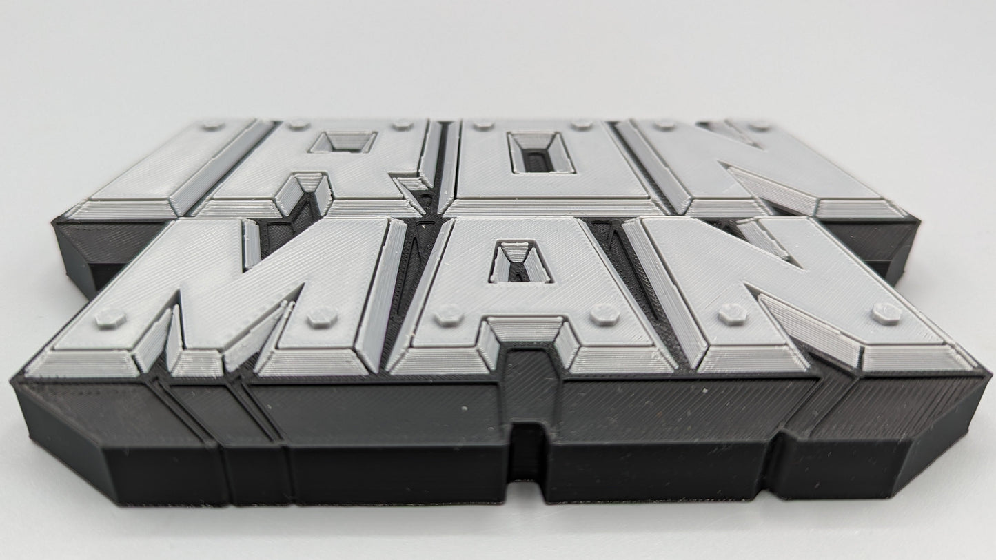 Metallic 'Iron Man' logo on a reflective surface