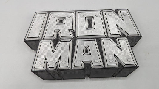 Metallic 'Iron Man' logo on a gray background