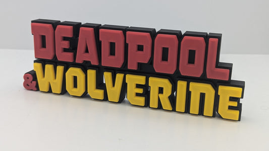 3D text sign featuring 'Deadpool & Wolverine' in red and yellow on a white background