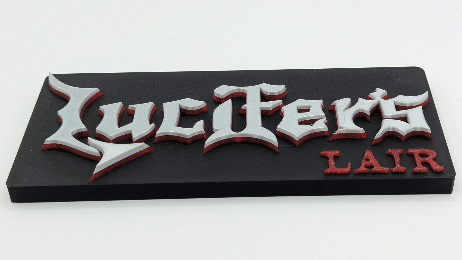 Decorative sign with 'Lucifer's Lair' text on a black background