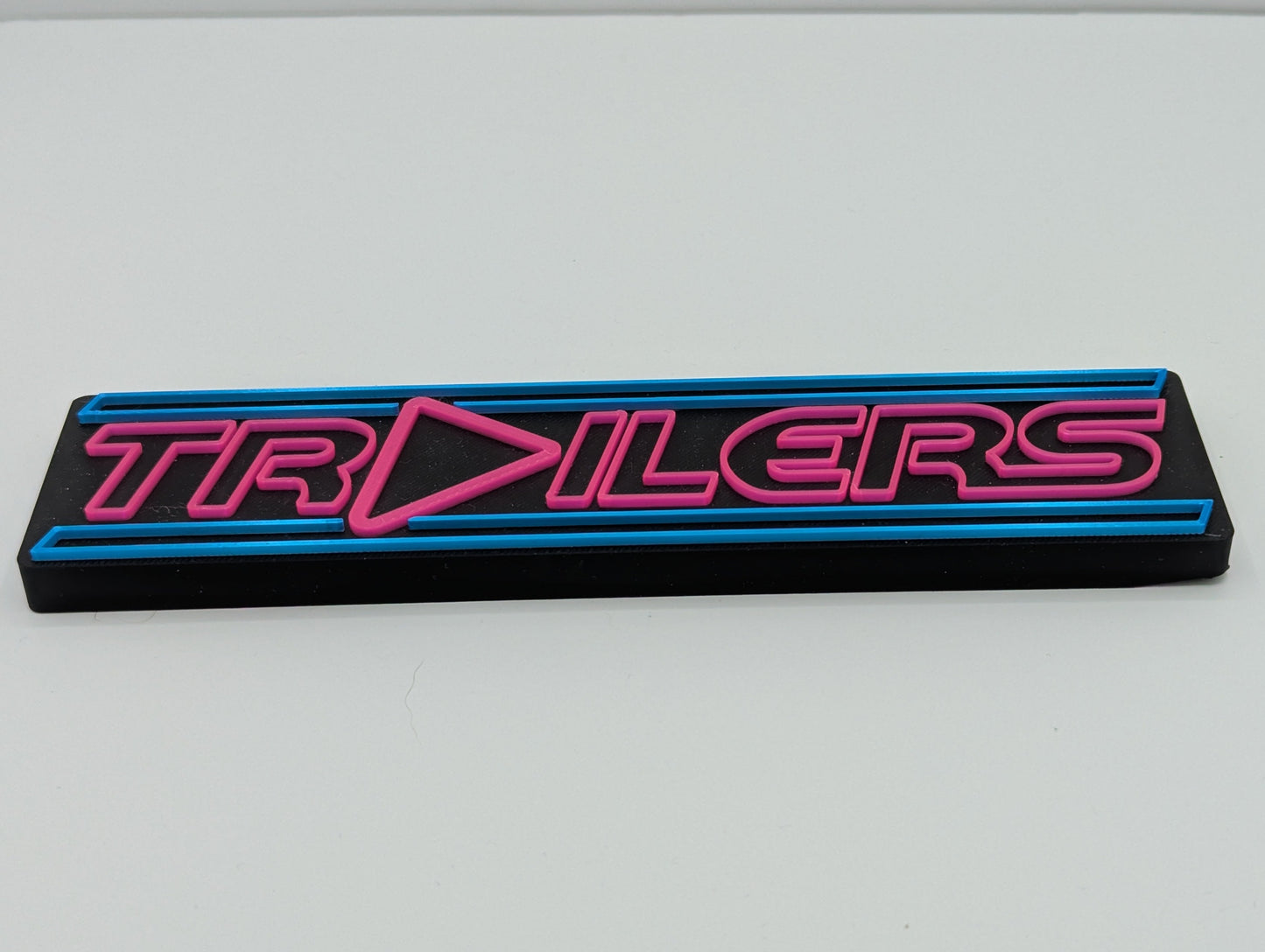 Logo with 'TRAILERS' text on a black background with pink and blue accents