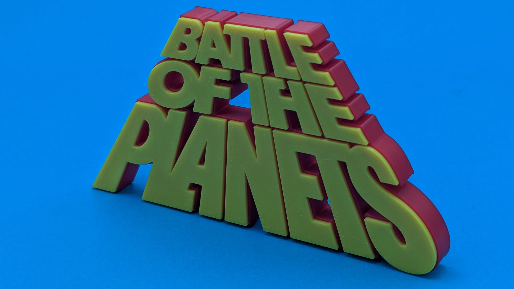 3D text 'BATTLE OF THE PLANETS' in red and green on a blue background