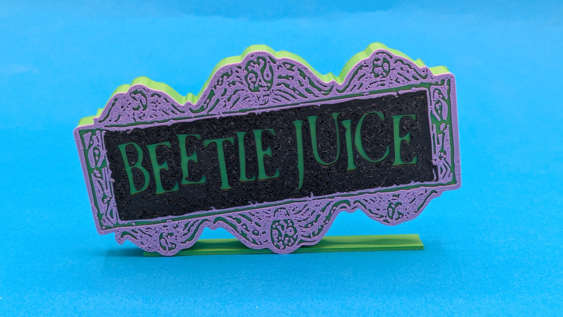 Decorative sign with 'Beetle Juice' text on a blue background