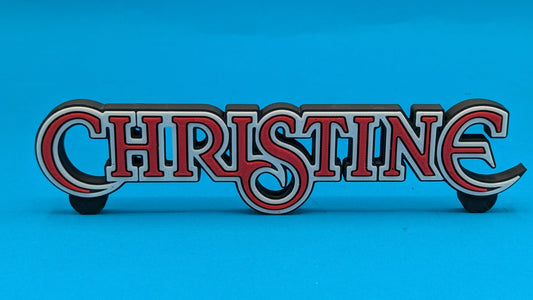 Decorative sign with 'CHRISTINE' in red and white on a blue background