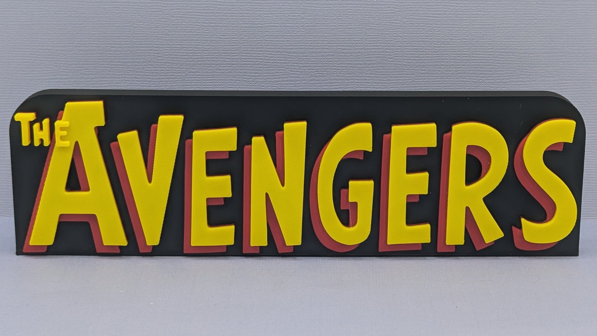 Logo of 'The Avengers' in yellow and red on a black background