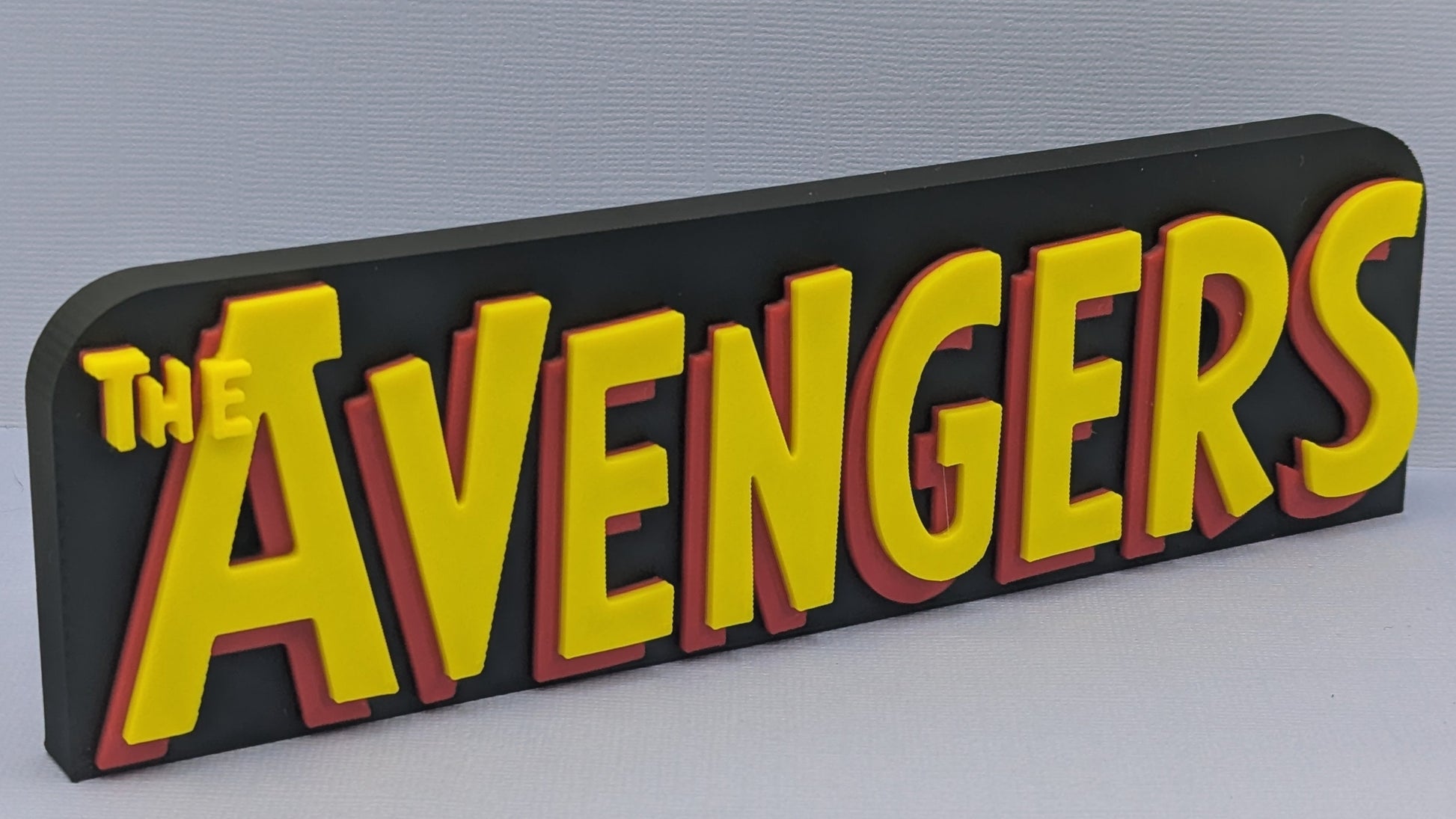 Decorative sign with 'The Avengers' text on a gray background