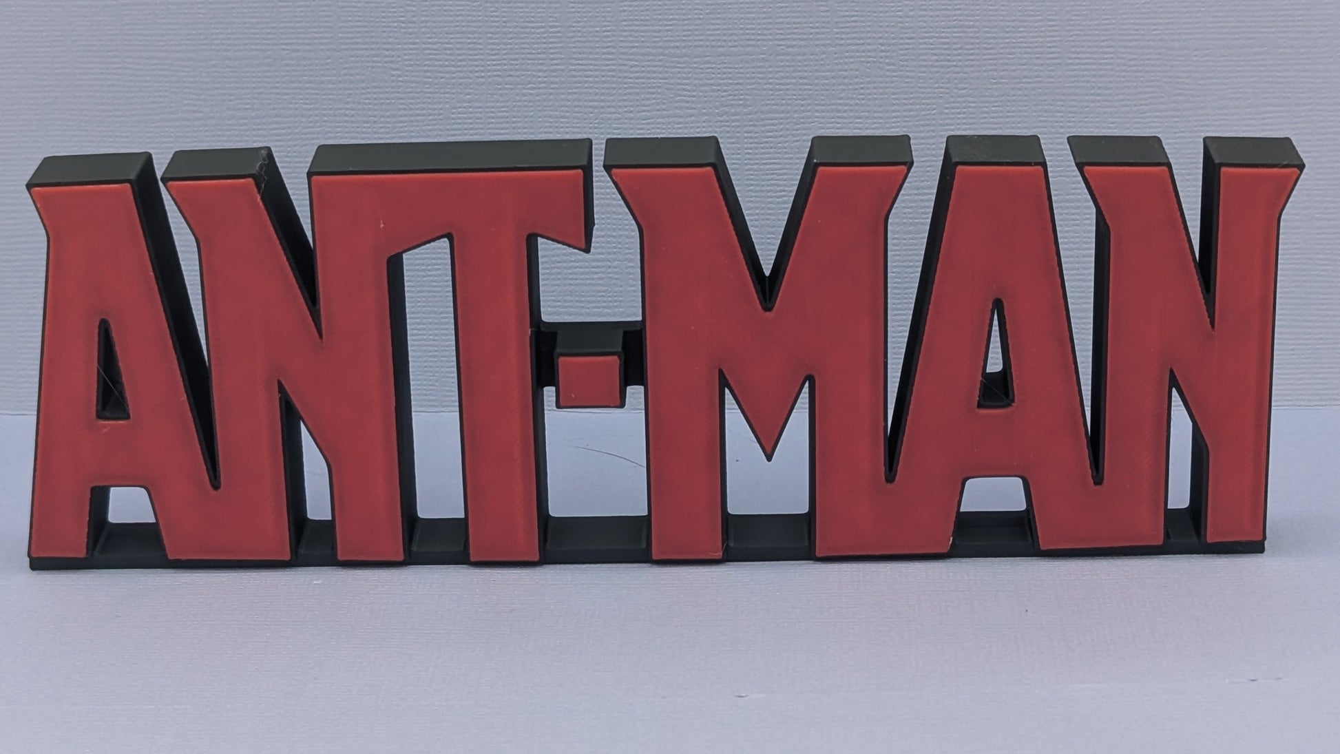 Red and black 'ANT-MAN' logo on a white background