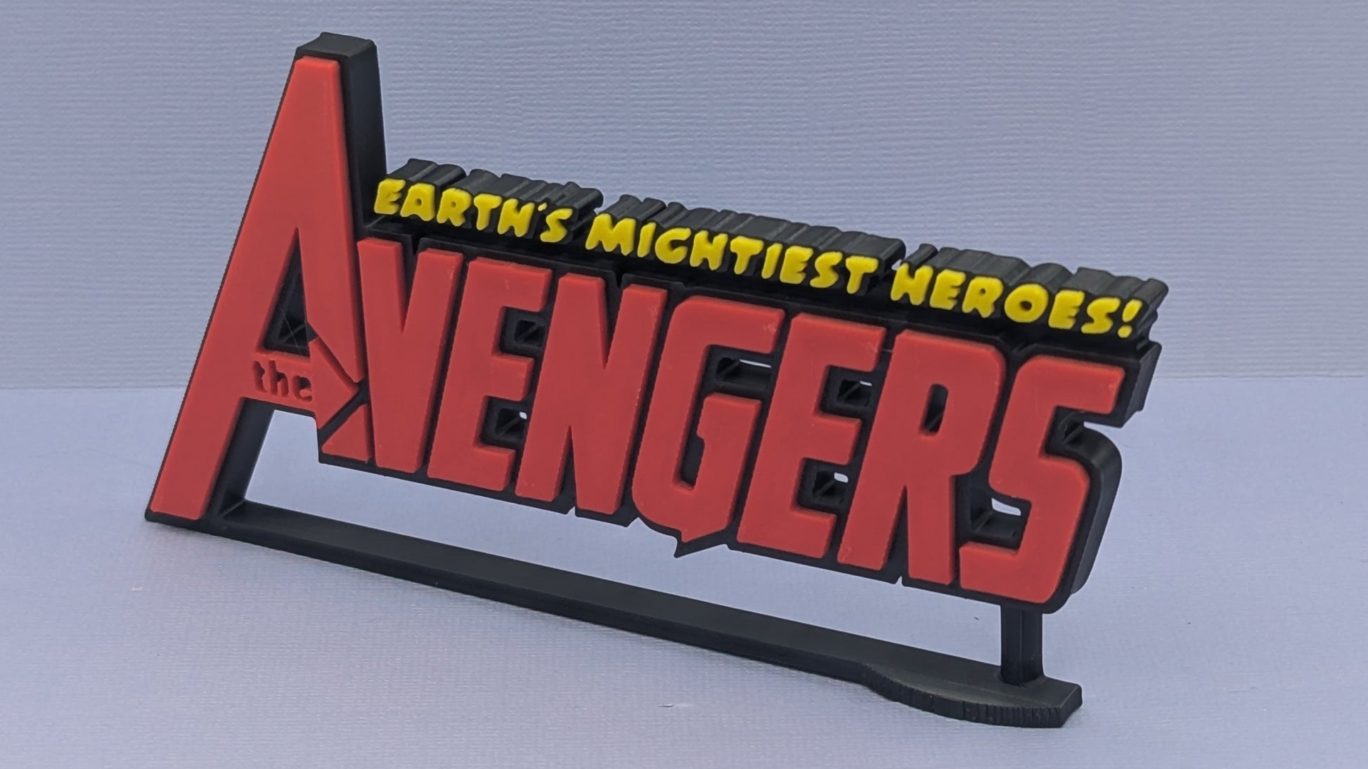 Avengers logo with 'Earth's Mightiest Heroes!' text on a gray background