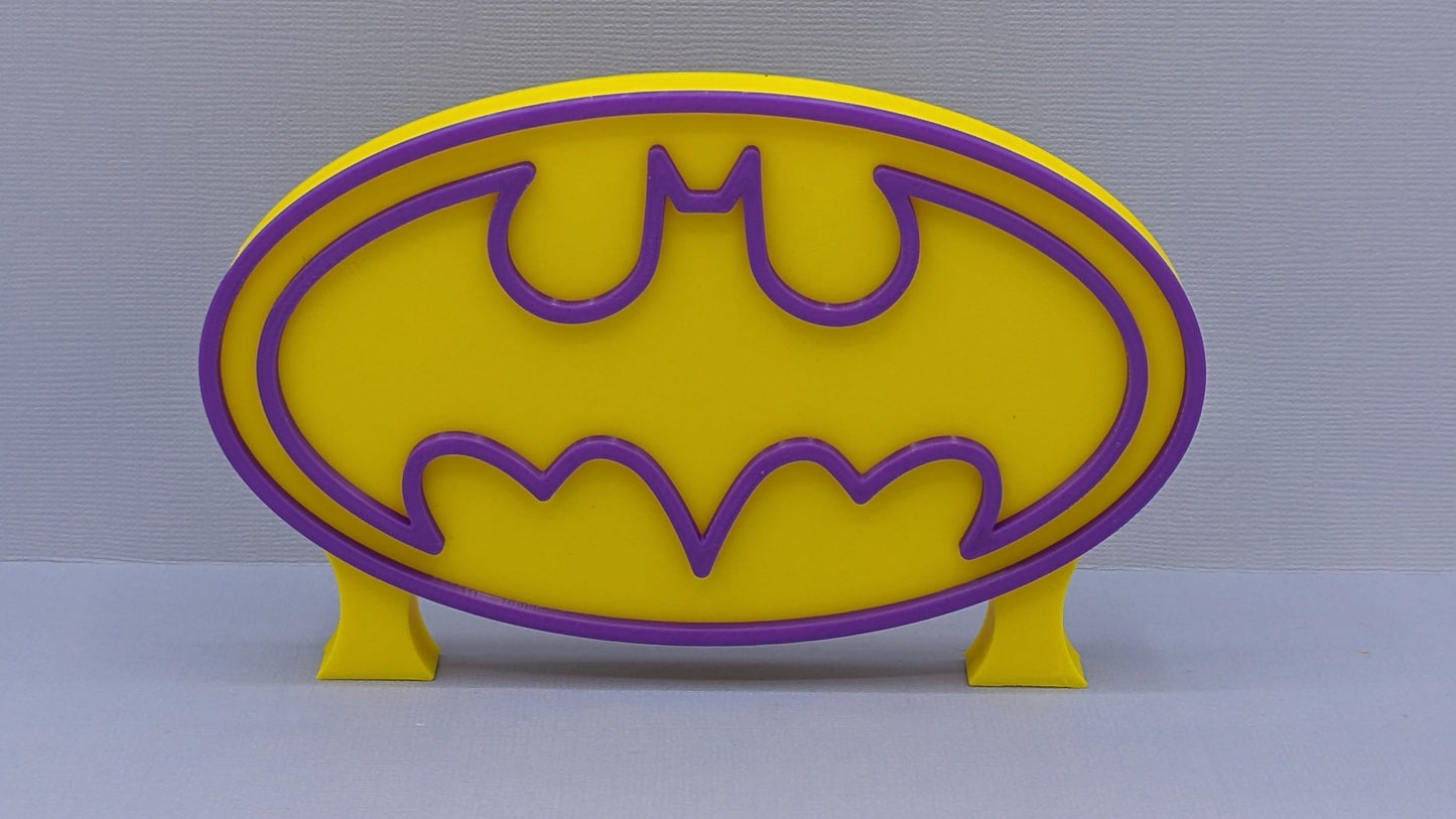 Yellow and purple bat symbol on a gray background