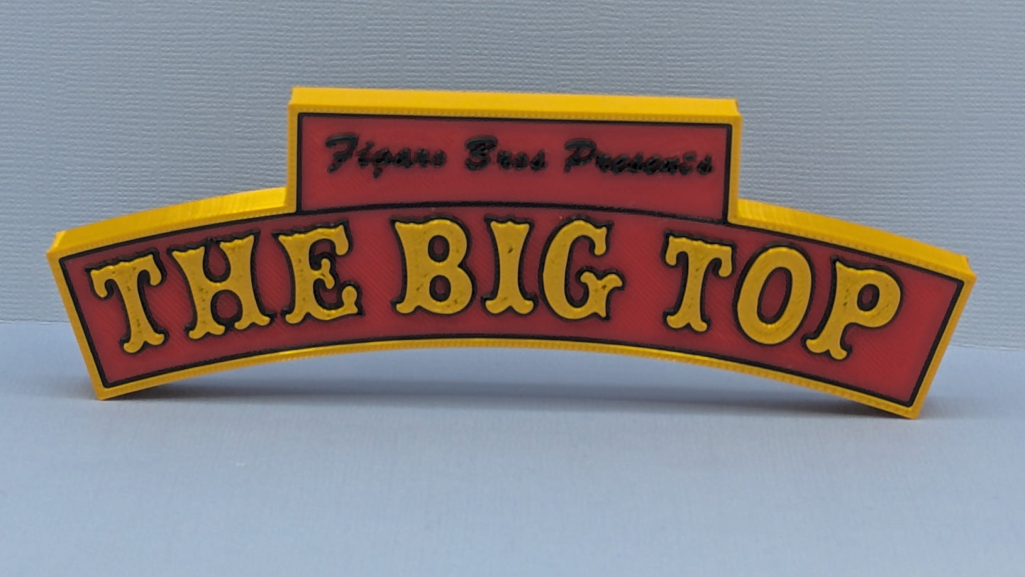 Decorative sign with 'The Big Top' text on a plain background