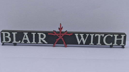 Decorative sign with 'Blair Witch' text and red star on a light gray background
