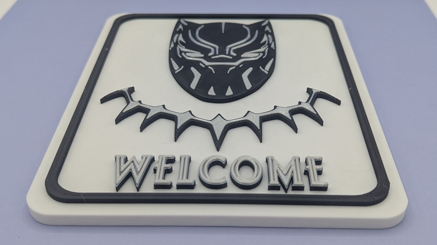 3D-printed 'Welcome' sign with black panther design on a light purple surface
