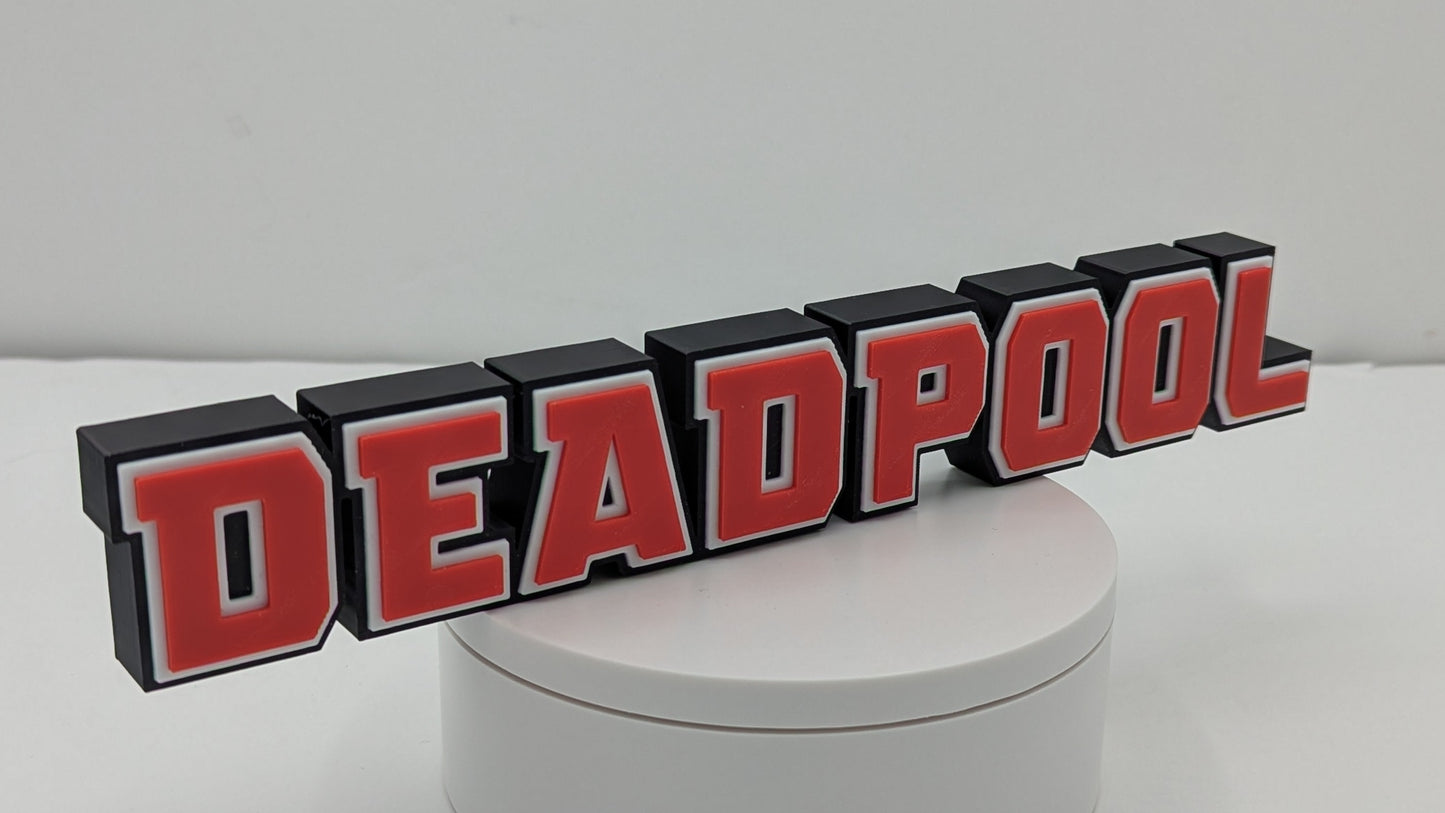 3D metal logo of 'DEADPOOL' on a white base with a white background