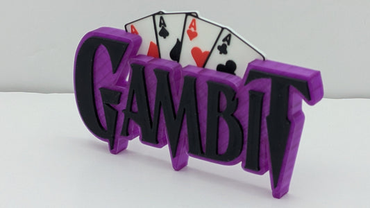 3D printed 'Gambit' logo with playing cards on a white background