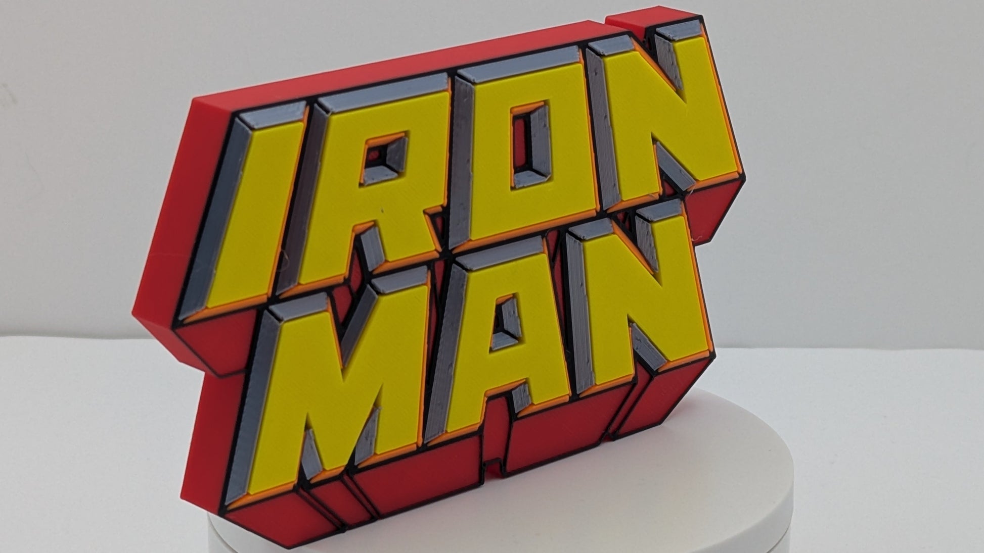 3D model of 'Iron Man' logo on a white pedestal