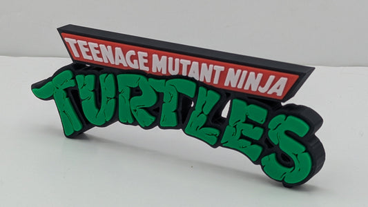 Decorative sign with 'Teenage Mutant Ninja Turtles' text on a white background