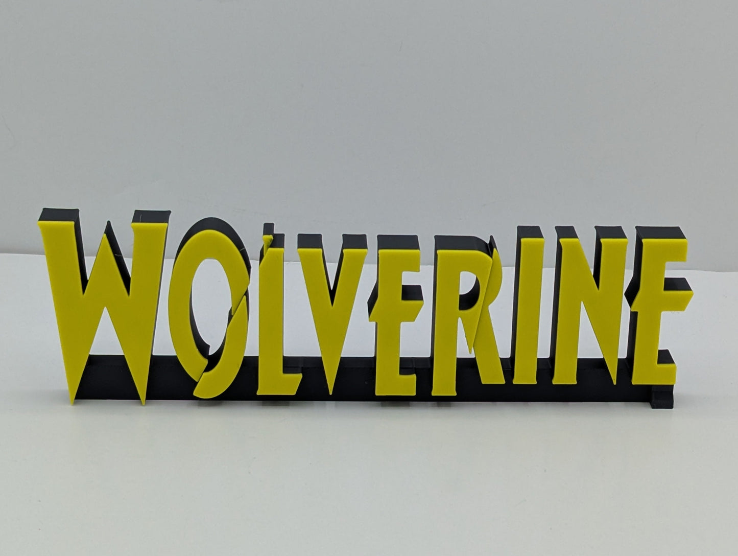 3D metallic text spelling 'WOLVERINE' on a white background
