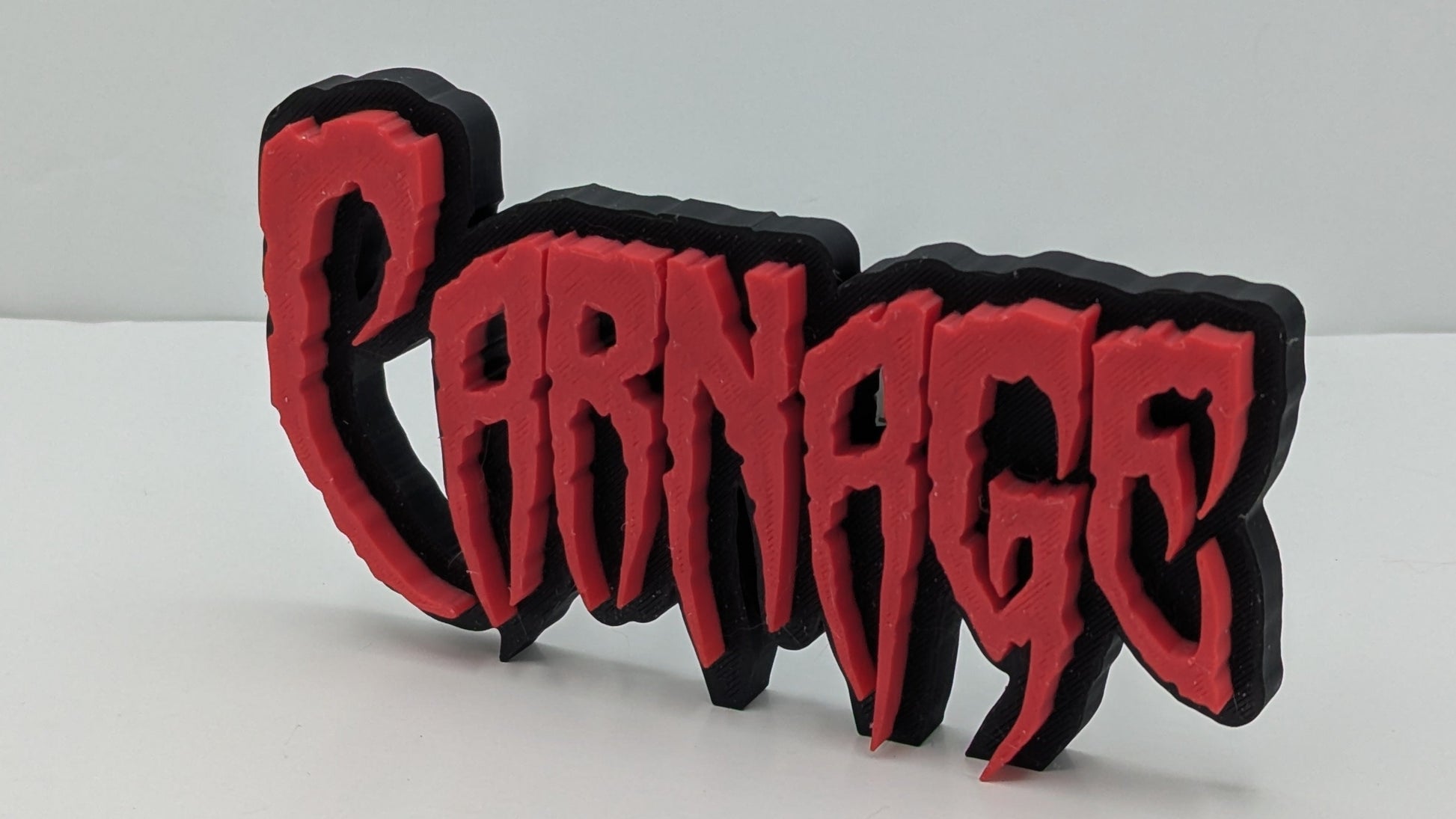 3D-printed 'Parnage' logo with red and black text on a white background