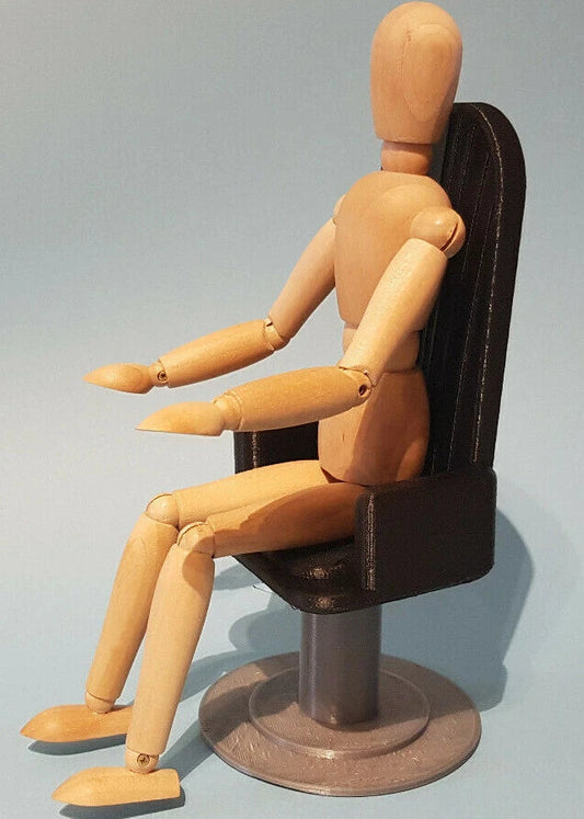 Wooden mannequin sitting on a black office chair against a gray background