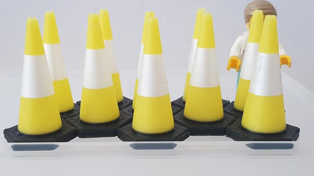 Model of a construction worker with traffic cones on a white background